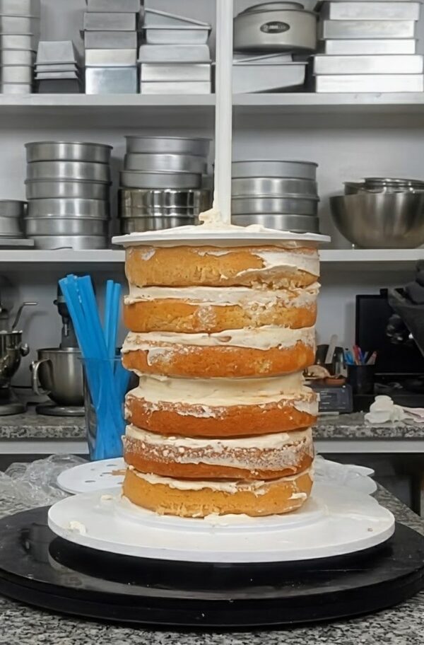 Acrylic cake frosting ring placed on a cake tier to guide smooth frosting and maintain even edges.