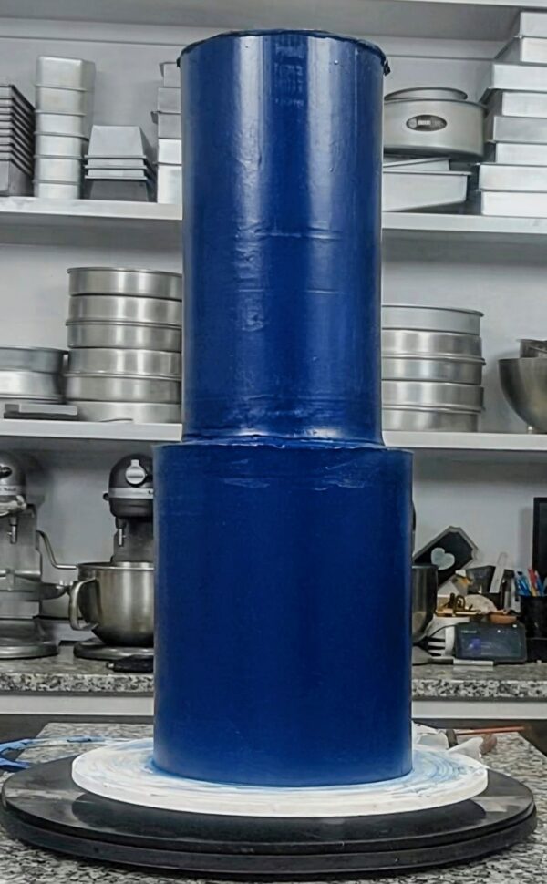 Perfectly frosted tiered cake with smooth, professional edges created using acrylic cake frosting rings.